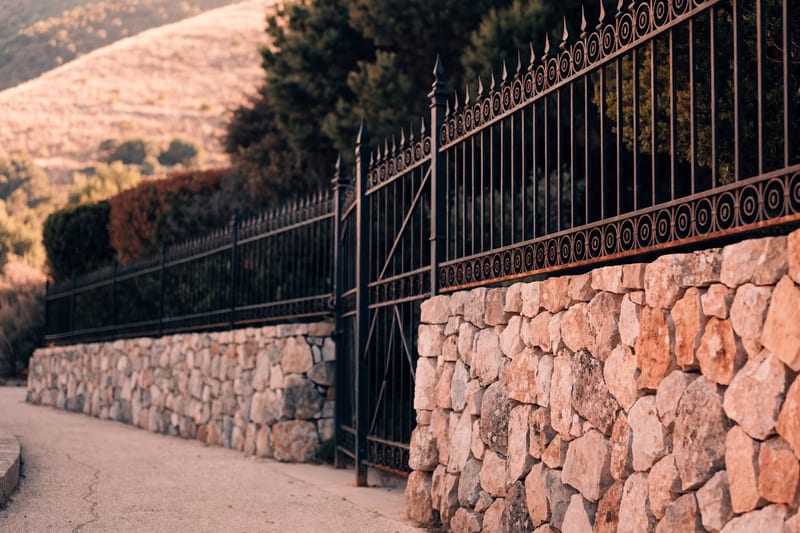 Schmiedeeiserner Zaun an einer Natursteinmauer auf Mallorca